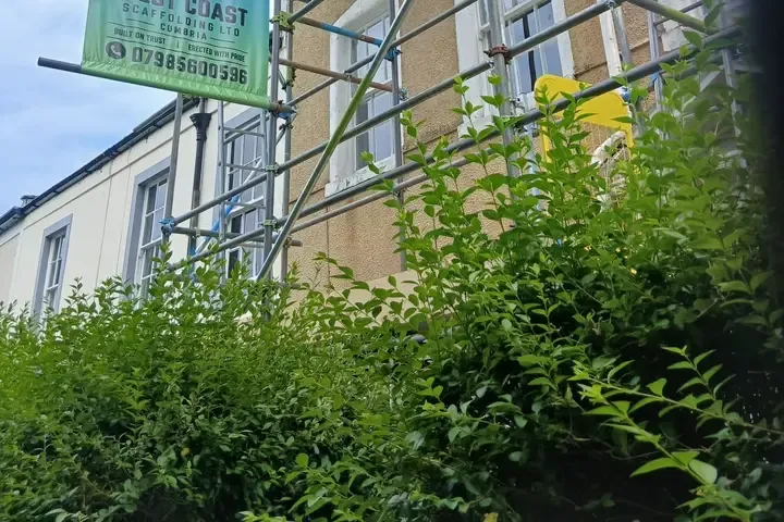 The West Coast Scaffolding banner tied to a scaffold on a rendered elevation, boarded lift above.